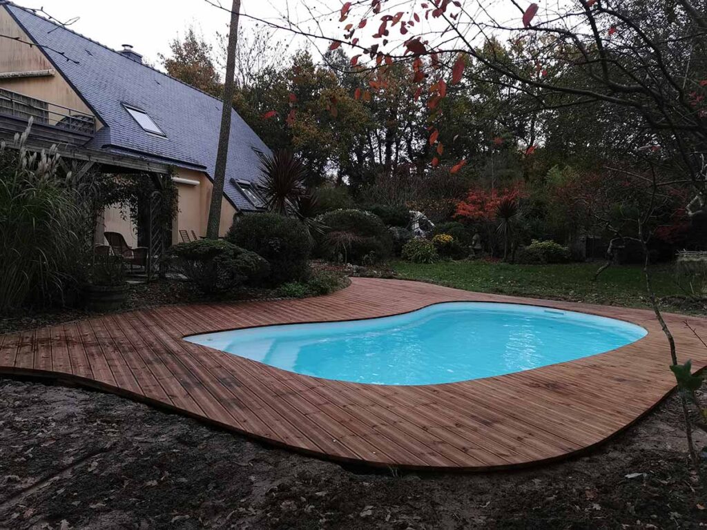 Installation d’une petite piscine courbe avec terrasse bois